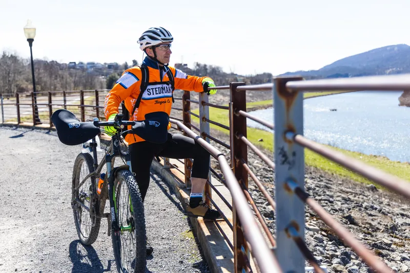 Man stands with a bicycle along a bike trail in Allegany Maryland.