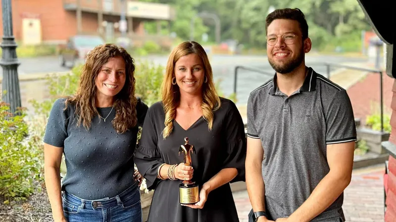 Three people stand with a 2024 Telly Award