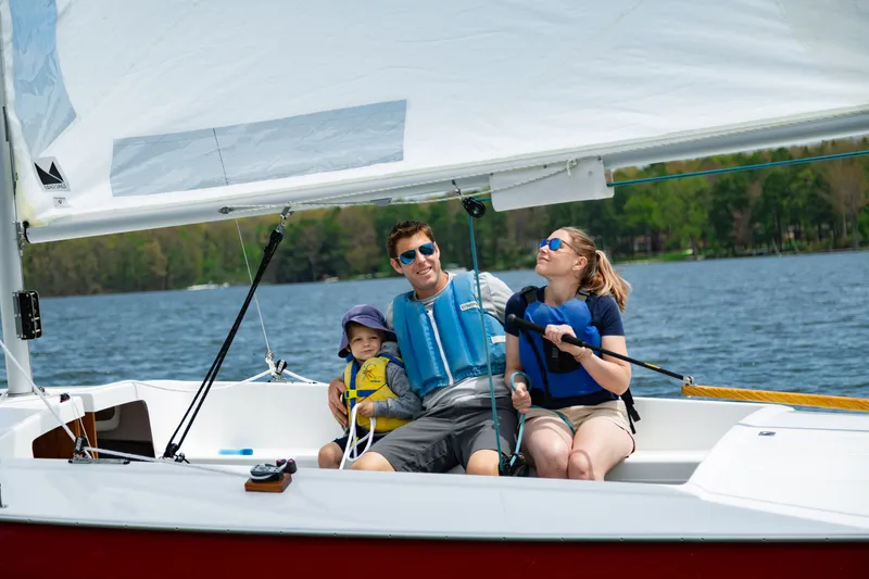 A man, woman, and child sail on a large white boat.