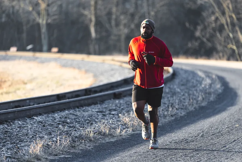 Man runs alongside a rail trail in Western Maryland.