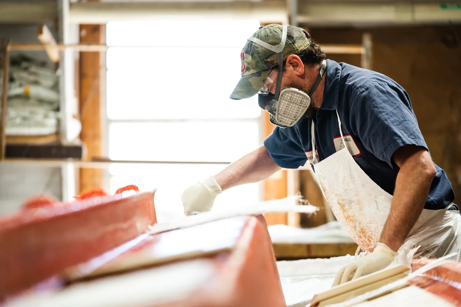 A craftsman works on a boat in the  Flying Scot Inc. workshop.