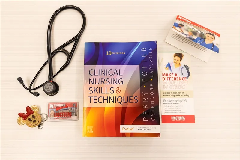 Frostburg State University Nursing Program textbook, stethoscope and other student materials on a table.