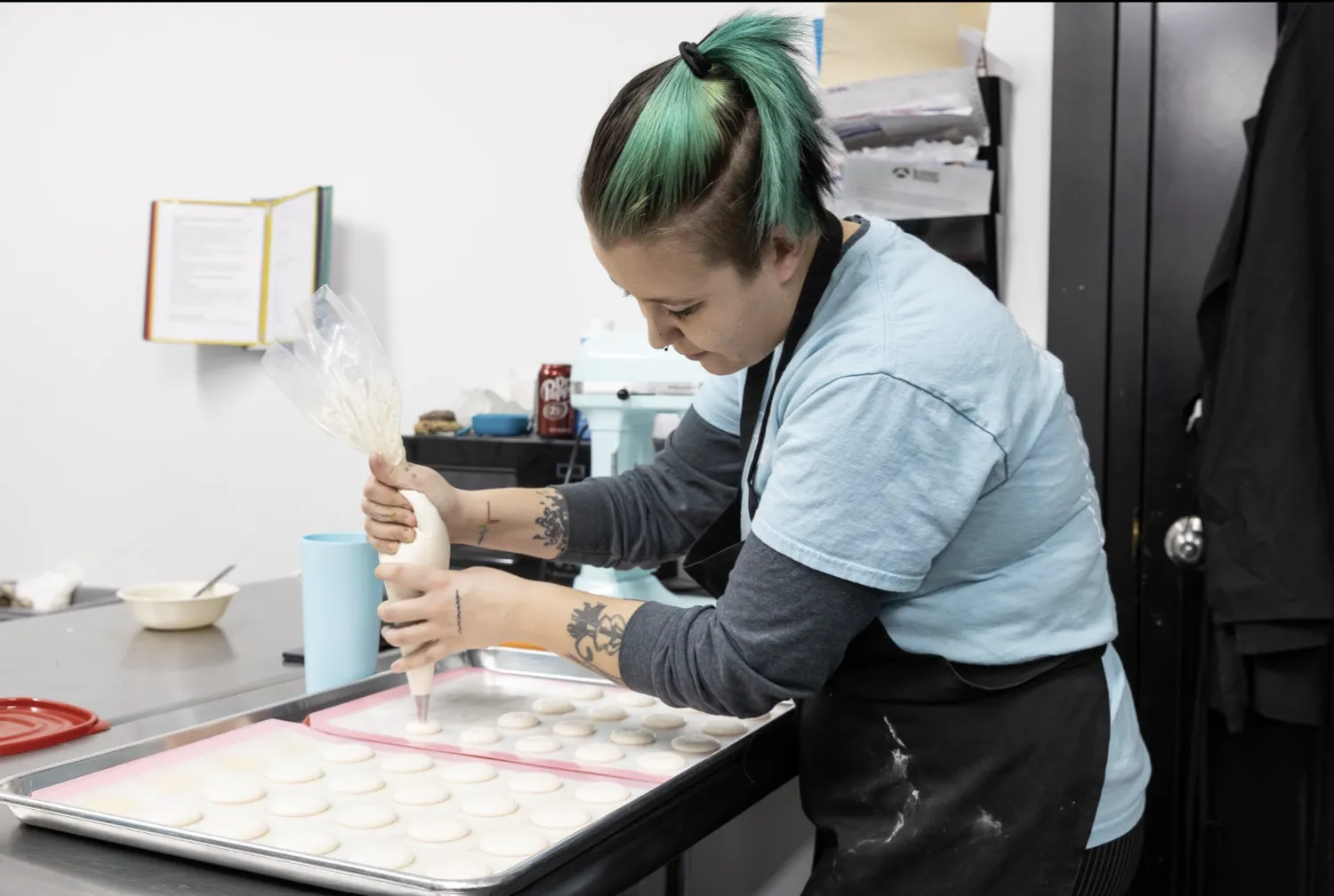 A chef pipes batter for French macarons in AJ's Cookie Jar, a boutique cookie shop inside The Rosenbaum.