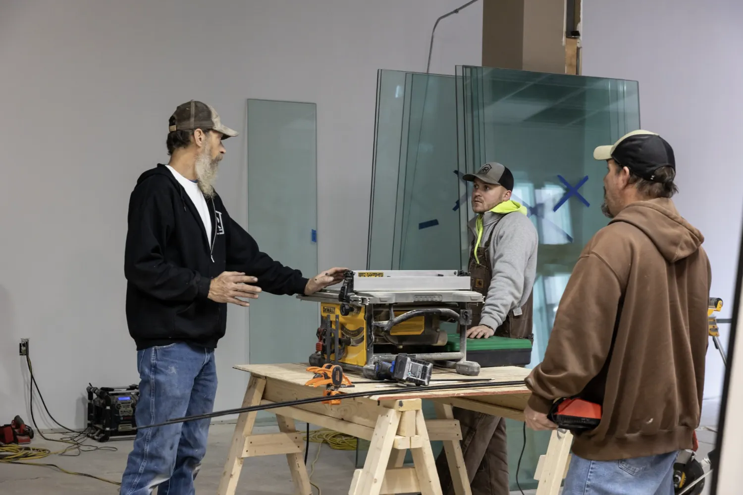 Construction workers stand around a workspace discussing the details of a project inside The Rosenbaum.